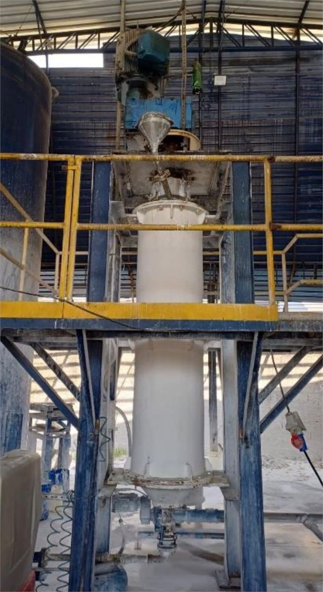 Moinho vertical em operação, com estrutura azul e plataforma de acesso